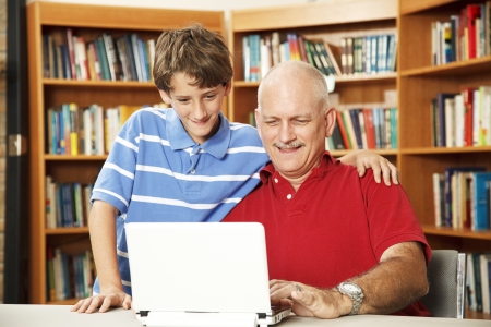 Father and son surfing the internet at the school library.  の写真素材