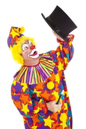 Confused clown looking for the rabbit he lost in a magic top hat.  Isolated on white.  の写真素材