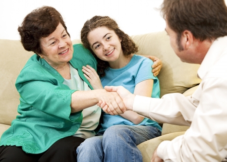 Mother and teen girl shake hands with a counselor.  の写真素材
