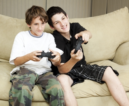 Two brothers at home playing video games together.  の写真素材