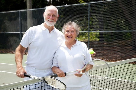 Portrait of a happy senior couple on the tennis courts.  の写真素材