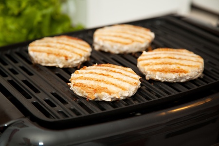 Healthy, low-fat turkey burgers cooking on indoor grill.  の写真素材