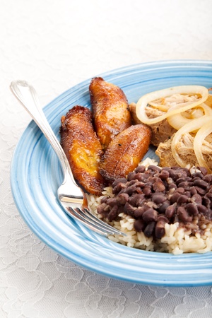 Traditional Cuban meal with sweet plantains, black beans and rice, and roast pork.  の写真素材