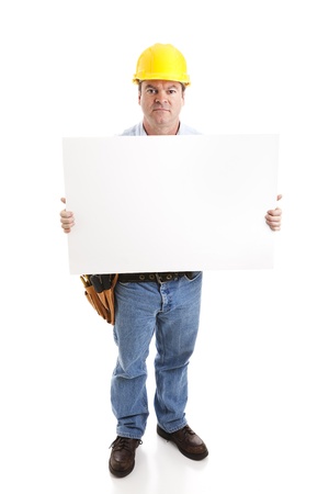 Construction worker with serious expression,  holding a blank white sign.  Isolated on white, full body.の写真素材