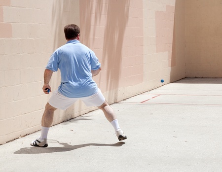 Mid adult man playing racquetball on a public court.