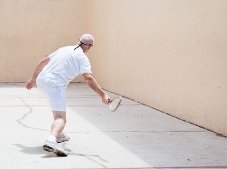 Senior man working out on a racquetball court.  の写真素材