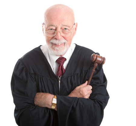 Wise, kind looking judge holding his gavel   Isolated on white background   の写真素材