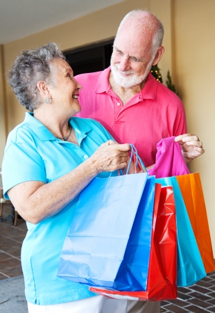 Senior woman shows her husband some of the bargains she got shopping   の写真素材