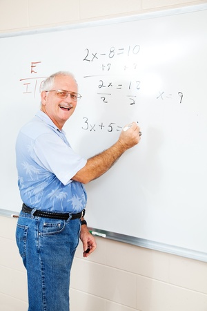 Middle aged teacher or adult education student writing algebra equations on the board.  の写真素材