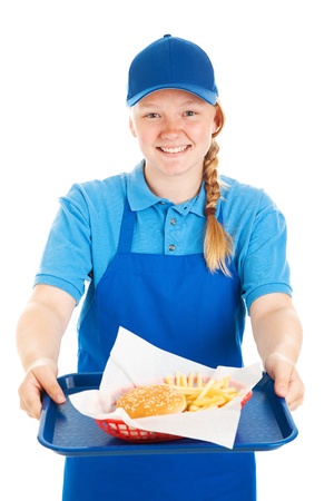 Friendly teenage fast food worker serving a burger and fries meal with a smile   Isolated on white   の写真素材