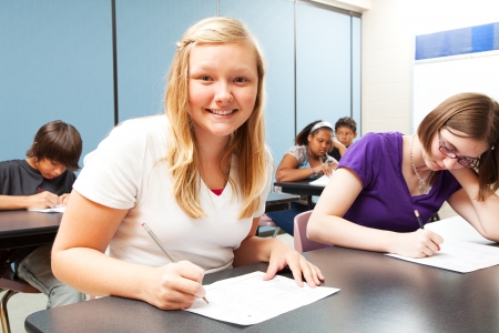 Pretty blond girl sitting in her high school class   の写真素材