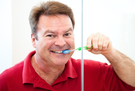 Happy, smiling man brushing his straight white teeth   の写真素材