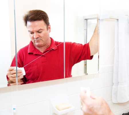 Man getting ready to floss his teeth with dental floss   