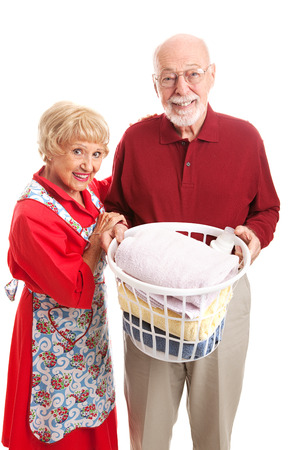 Senior man helps his wife with the laundry.  Isolated on white.  の写真素材