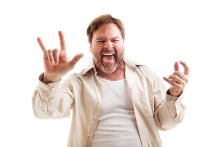 Middle-aged man rocks out playing air guitar and making the rock-n-roll symbol.  Isolated on white.  の写真素材