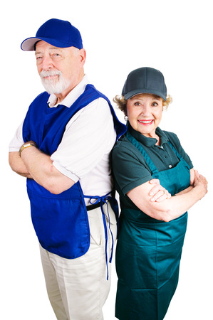 Senior couple working minimum wage jobs to supplement retirement income.  Isolated on white.の写真素材