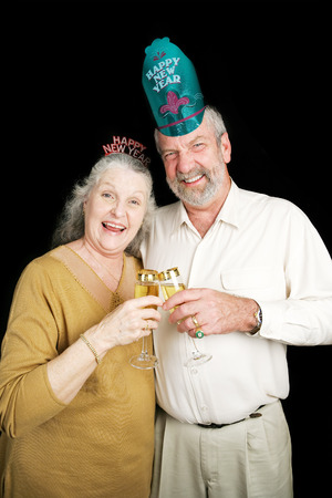 Senior couple a bit drunk on champagne at a New Year's Eve party.  Black background.の写真素材