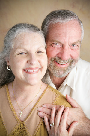 Portrait of beautiful happy senior couple in a traditional Christian marriage.  She is wearing a cross.の写真素材