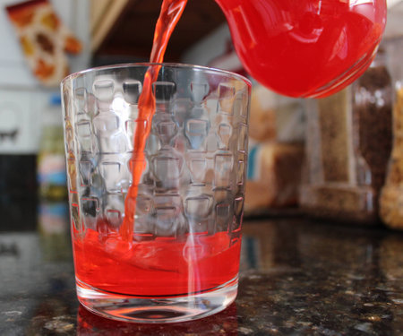 Pouring Red Fruit Drink into Glassの写真素材