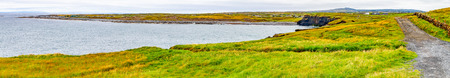 Panorama of Cliffs of Moher trail with Doolin village and farm fields in background, Clare, Ireland