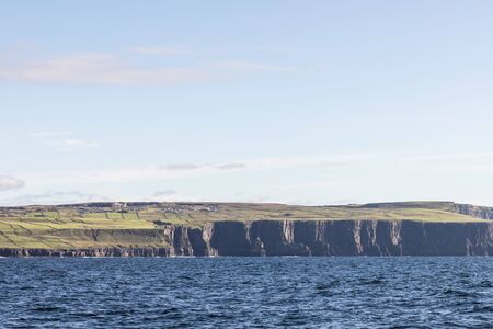 Farm fields and houses over Cliffs of Moher in Doolin, Ireland