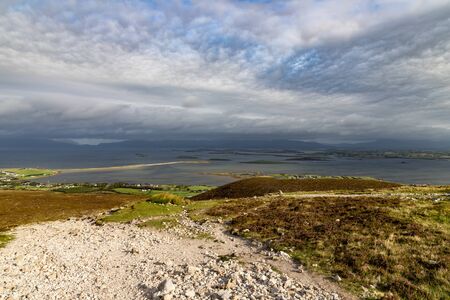 Rocks and vegetation at Croagh Patrick mountain with Westport in background, Westport, Ireland