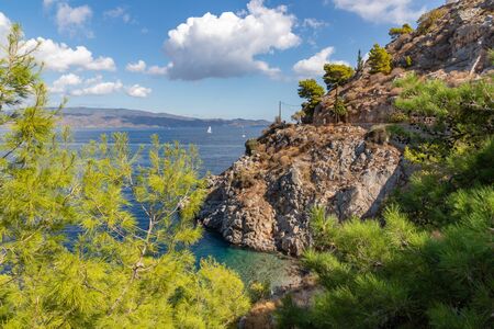 Beach with rocks and vegetation in Hydra Island, Greeceの写真素材