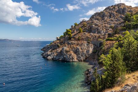 Beach with rocks and vegetation in Hydra Island, Greeceの写真素材