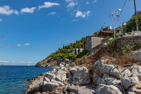 Rocks and buildings around Kamini beach in Hydra Island, Greeceの写真素材