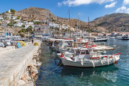 Boats in the pier with houses and buildings in background in Hydra Island, Greeceの写真素材