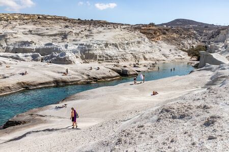 People enjoying white Cliffs in SarakÃ­niko beach, Milos, Greeceの写真素材