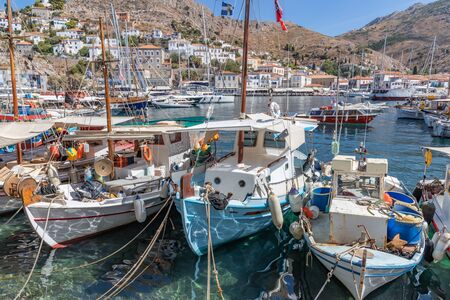 Boats in the pier with houses and buildings in background in Hydra Island, Greeceの写真素材