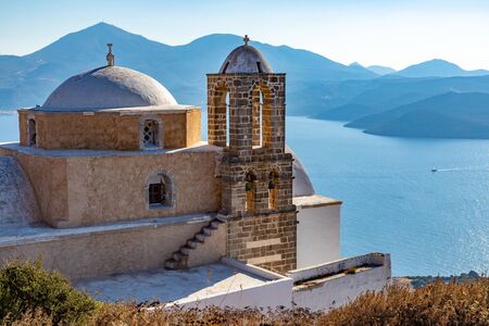 Church  in Plaka village with bay in background, Milos, Greeceの写真素材