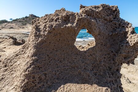 Rock with a wind hole in Pachena beach, Milos, Greece