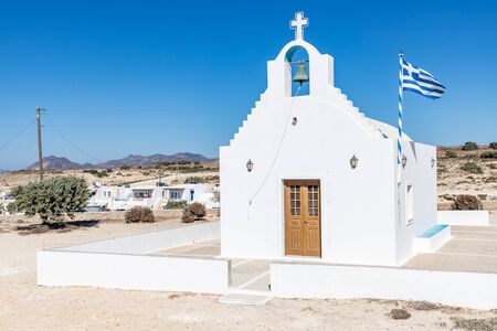 Agios Konstantinos church and Greek flag, Milos, Greeceの写真素材