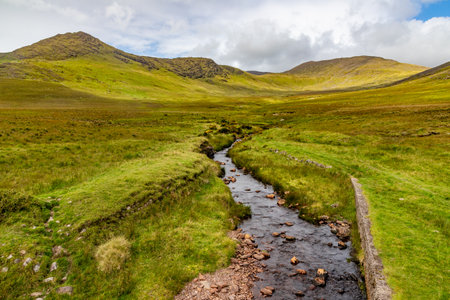 Small river, mountains and fields in Dromalonhurt, Kerry, Irelandの写真素材