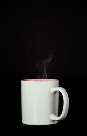 white cup with smoke coming out of it on a black backgroundの写真素材