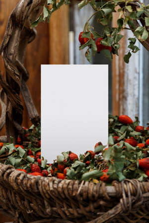 Blank white greeting card and old graceful basket. Mockup with vintage basket of vines and rose...