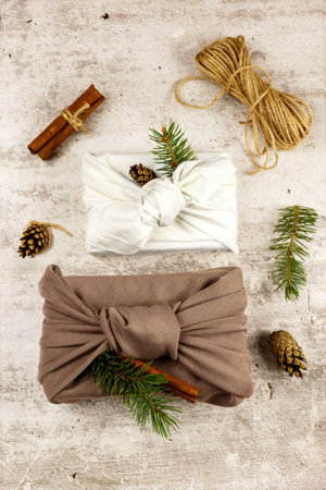 Japanese wrapping cloth Furoshiki, traditionally used to transport gifts. Present boxes with fir, pine cones, cinnamon and rose hips. Zero waste concept.の写真素材