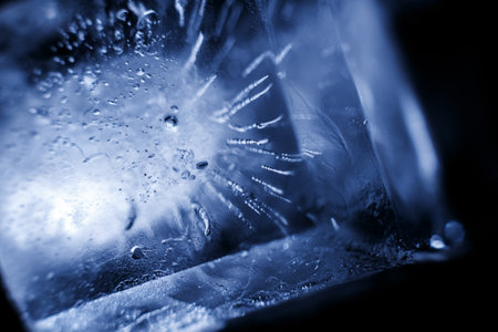 Crystal ice cubes reflection on black background. Extreme close up natural ice block on dark...