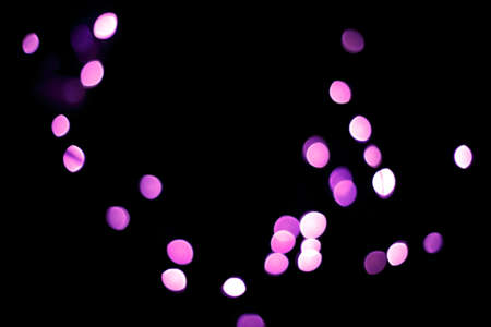 Purple light blurred. Abstract boken texture. Festive background. Glitter light spots on black...