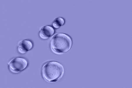 Cosmetic hydrating product or ingredient concept. Blue drops of transparent liquid on a very peri...