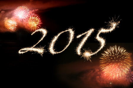 Fireworks against a black background surrounding 2015 written in sparklers representing  celebrating the New Year.の写真素材