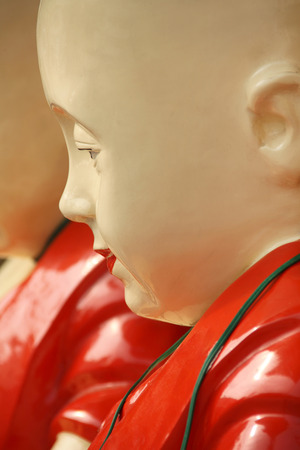Close up of the head of a painted cream & red Thai Buddha statue, China Town, Bangkok, Thailand.の写真素材