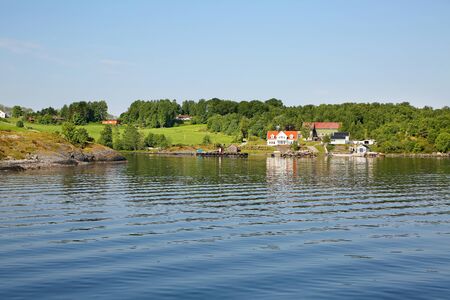 Beautiful islands with villages, wooden houses & trees along the coastline and fjords. Lysefjord,...