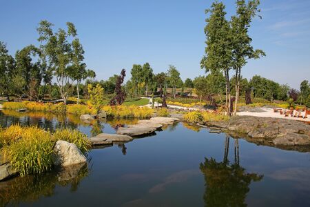 Reflections in the water at beautiful landscape with plants, flowers, trees, gardens on the islands outside Stavanger, Norway.の写真素材