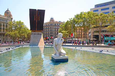 Beautiful sculpture of a woman in a water feature or pond, at the center of the city in the downtown area, Placa de Catalunya or Catalonia Square, Barcelona, Spain.のeditorial素材
