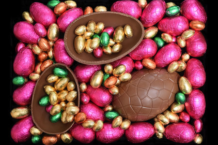 Pile or group of multi colored and different sizes of colourful foil wrapped chocolate easter eggs...