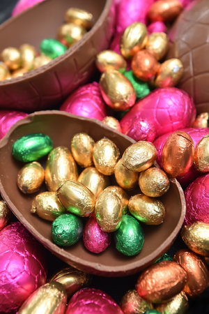 Pile or group of multi colored and different sizes of colourful foil wrapped chocolate easter eggs...