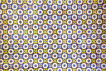 Traditional glazed blue, yellow and white ceramic tiles or azulejos which cover many buildings in Lisbon, Portugal. These Portugese tiles have many different geometric or floral designs and colours.の写真素材